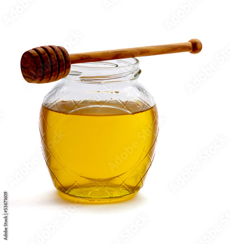 Photo: Honey with wood stick , isolated on white background Honey with wood stick , isolated on white background