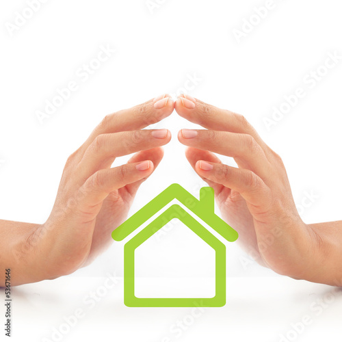 Photo: Woman hands over green house. Woman hands over green house.