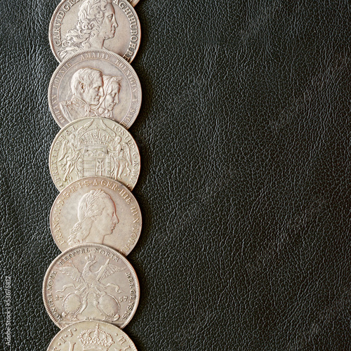 Photo: Ancient silver coins on a leather surface Ancient silver coins on a leather surface