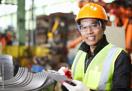 Photo: Portrait of young engineer taking notes Portrait of young engineer taking notes
