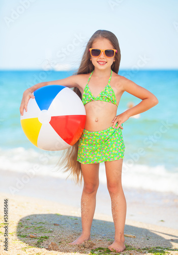 Photo: child with sunglasses and ball at the beach child with sunglasses and ball at the beach