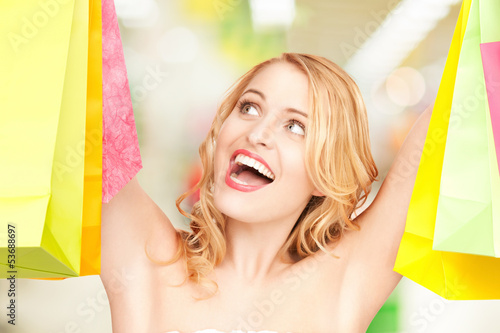 Photo: woman holding color shopping bags in mall woman holding color shopping bags in mall