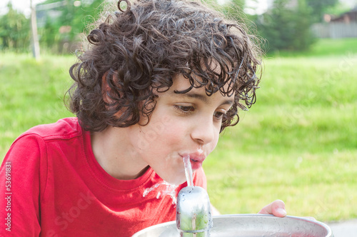 Photo: Child drinking from a water fountain Child drinking from a water fountain