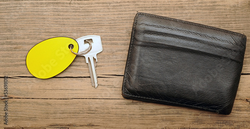 Photo: wallet and key with blank label on wood background wallet and key with blank label on wood background