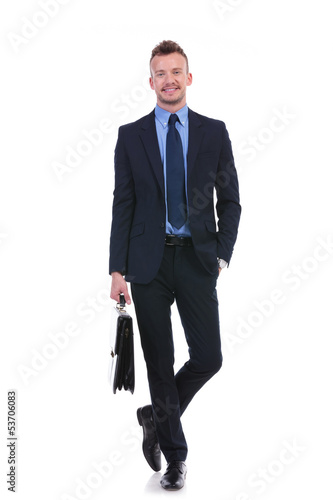 Photo: business man stands with suitcase and hand in pocket business man stands with suitcase and hand in pocket