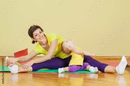 Photo: Mother do phisical exercises with her daughter at home Mother do phisical exercises with her daughter at home