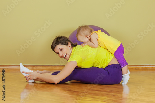 Photo: Mother do phisical exercises with her daughter at home Mother do phisical exercises with her daughter at home