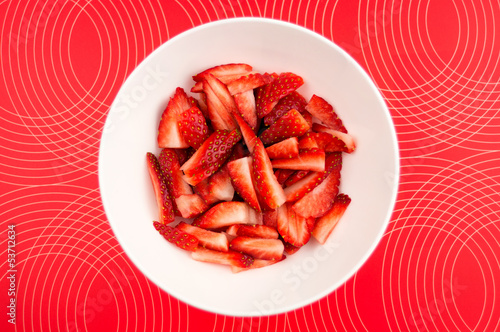 Photo: Chopped strawberries in a bowl against a patterned background Chopped strawberries in a bowl against a patterned background