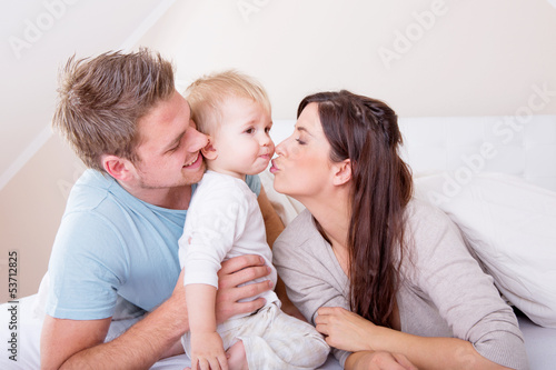 Photo: smiling familiy in the bed smiling familiy in the bed