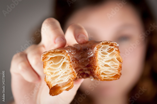 Photo: Croissant and doughnut mixture being held by a girl Croissant and doughnut mixture being held by a girl