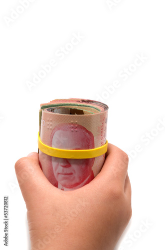 Photo: Hand holding a roll of 50 dollars Canadian with yellow plastic b Hand holding a roll of 50 dollars Canadian with yellow plastic b