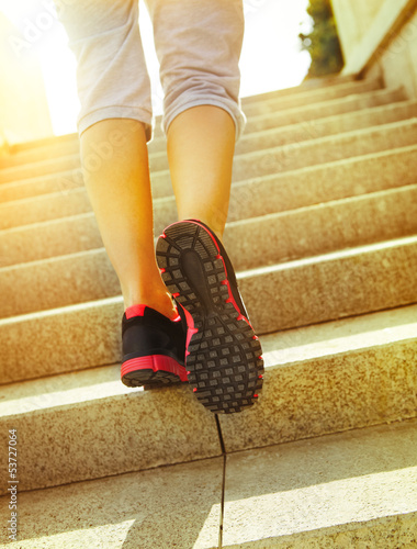 Photo: Runner feet running on road closeup on shoes Runner feet running on road closeup on shoes