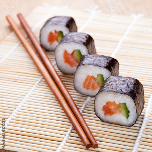 Photo: Delicious fresh sushi rolls on the mat Delicious fresh sushi rolls on the mat