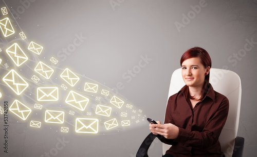 Photo: attractive young lady holding a phone with message icons attractive young lady holding a phone with message icons