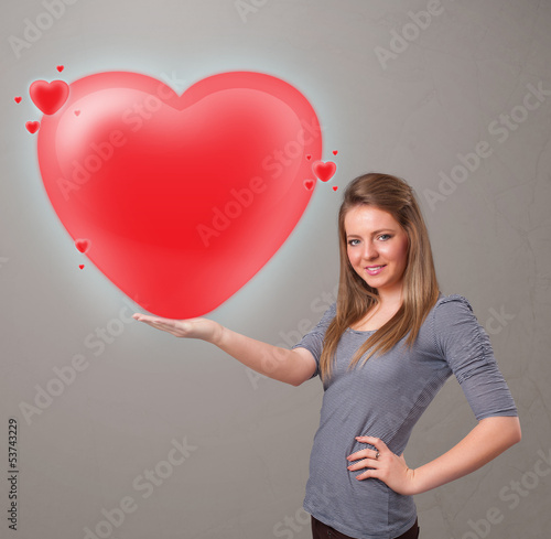 Photo: Young lady holding lovely 3d red heart Young lady holding lovely 3d red heart