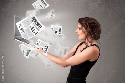 Photo: Casual young woman holdin notebook and reading the explosive new Casual young woman holdin notebook and reading the explosive new