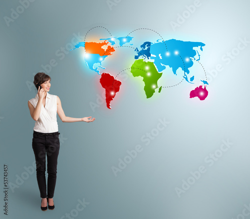 Photo: young woman making phone call with colorful world map young woman making phone call with colorful world map