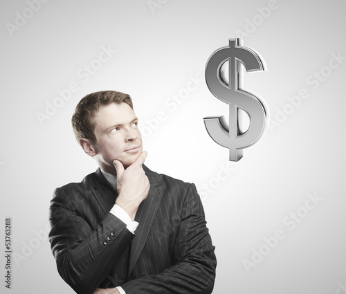 Photo: man looking on doollar sign man looking on doollar sign
