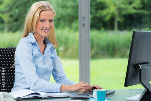 Photo: businessfrau sitzt am computer businessfrau sitzt am computer