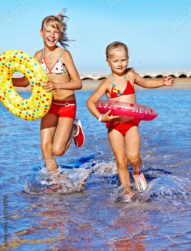 Photo: Children holding hands running on beach. Children holding hands running on beach.