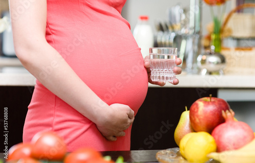 Photo: pregnant woman holding a glass of clean water pregnant woman holding a glass of clean water