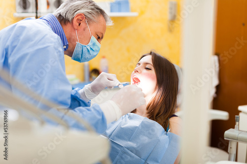 Photo: Dentist doing a treatment Dentist doing a treatment