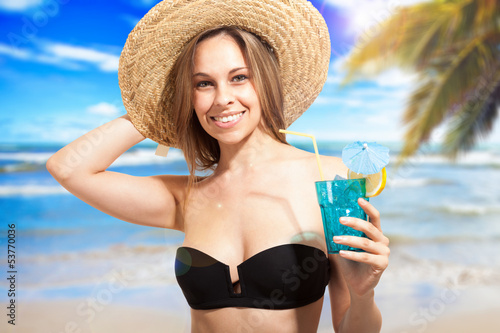 Photo: Woman drinking a cocktail on the beach Woman drinking a cocktail on the beach