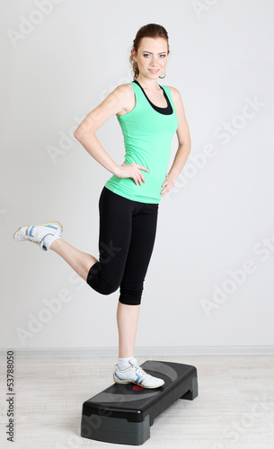 Photo: Beautiful young woman exercises on stepper Beautiful young woman exercises on stepper