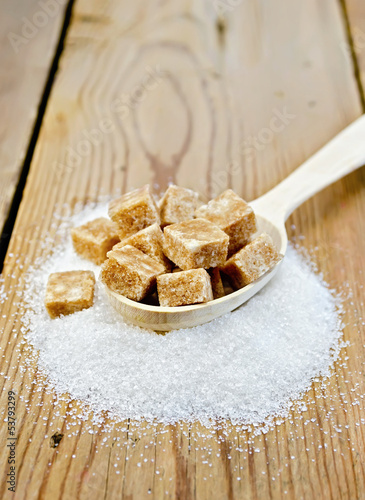 Photo: Sugar brown and granulated sugar in a spoon on the board Sugar brown and granulated sugar in a spoon on the board