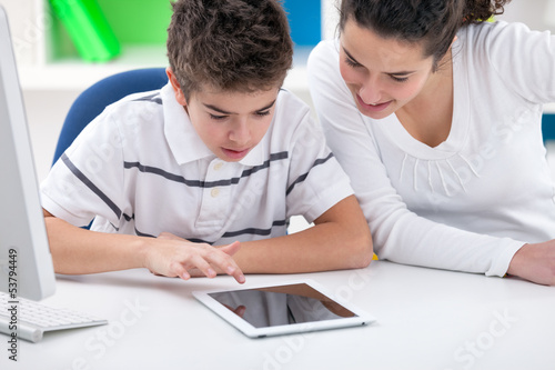 Photo: sister and brother playing game on tablet pc sister and brother playing game on tablet pc