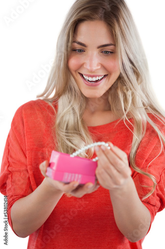 Photo: Blonde woman discovering necklace in a gift box Blonde woman discovering necklace in a gift box
