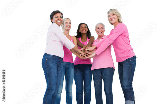 Photo: Cheerful women wearing breast cancer ribbons with hands together Cheerful women wearing breast cancer ribbons with hands together