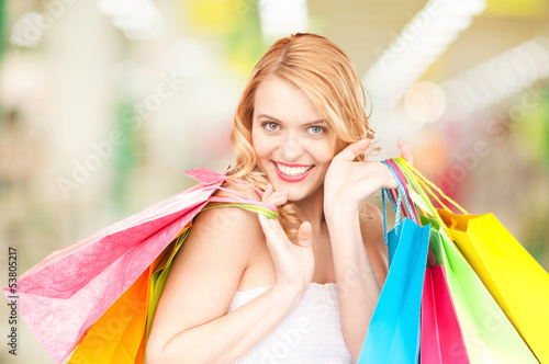 Photo: woman holding color shopping bags in mall woman holding color shopping bags in mall