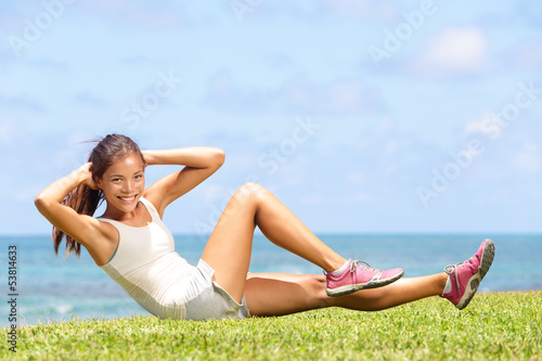Photo: Exercising fitness woman doing sit ups outside Exercising fitness woman doing sit ups outside