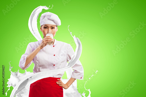 Photo: Asian female cook against milk splashes Asian female cook against milk splashes