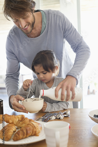 Photo: Man giving milk to his daughter Man giving milk to his daughter