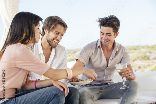 Photo: Three friends enjoying snacks and drinks in outdoor Three friends enjoying snacks and drinks in outdoor