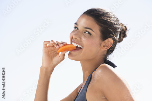 Photo: Beautiful woman eating a slice of papaya Beautiful woman eating a slice of papaya