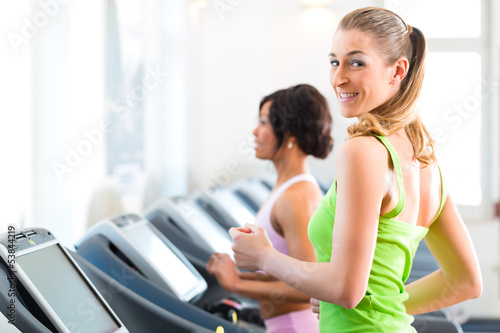 Photo: People in sport gym on treadmill running People in sport gym on treadmill running