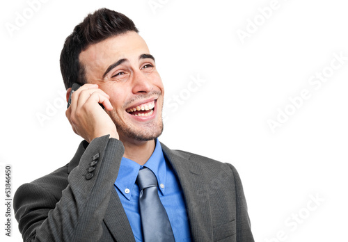 Photo: Smiling businessman talking at the phone isolated on white Smiling businessman talking at the phone isolated on white