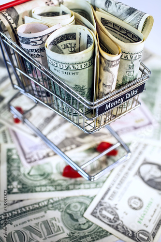 Photo: shopping trolley full dollar bill, greenback shopping trolley full dollar bill, greenback