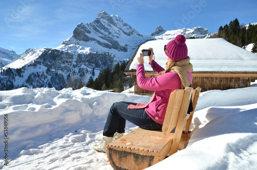 Photo: Girl taking a photo in the Swiss Alps Girl taking a photo in the Swiss Alps