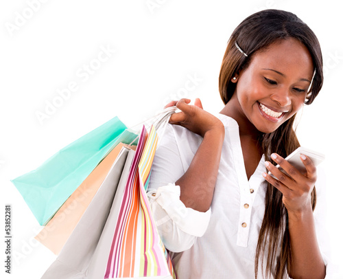 Photo: Shopping woman texting on her phone Shopping woman texting on her phone