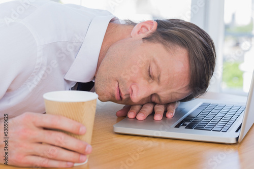 Photo: Businessman having a nap on his laptop Businessman having a nap on his laptop