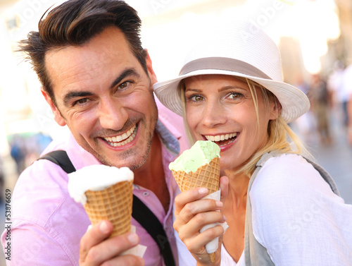 Photo: Cheerful couple in Rome eating ice cream cones Cheerful couple in Rome eating ice cream cones
