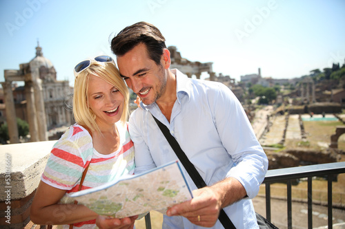 Photo: Couple of tourists reading city map by the Roman Forum Couple of tourists reading city map by the Roman Forum