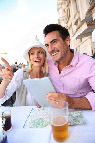 Photo: Tourists in Rome using tablet while having drink Tourists in Rome using tablet while having drink