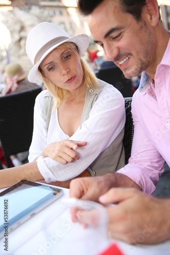 Photo: Tourists in Rome using tablet while having a drink Tourists in Rome using tablet while having a drink