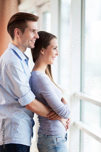 Photo: Couple looking through window Couple looking through window