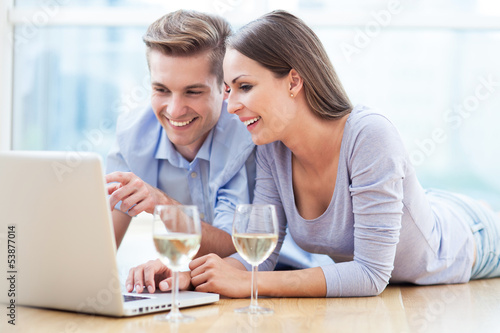 Photo: Couple on floor using laptop Couple on floor using laptop